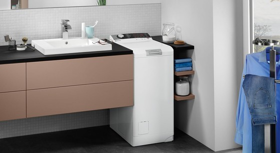 waschmaschine toploader in badezimmer neben lavabo