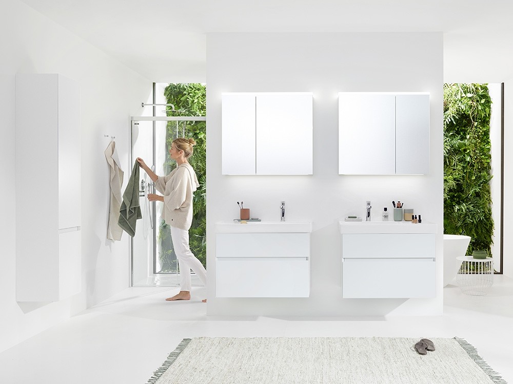 Minimalistisches Badezimmer mit weissen Möbeln und Pflanzenwand