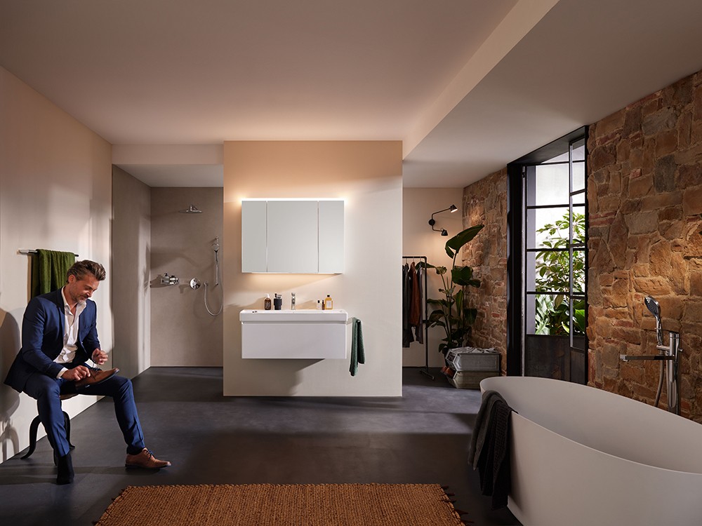 Offenes Badezimmer mit freistehender Badewanne und Steinwand