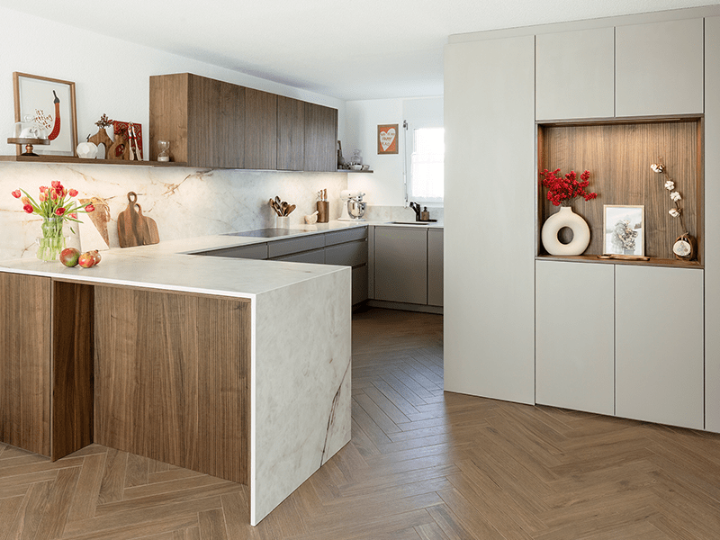 Offene Wohnküche in G-Form mit Holzfronten und Keramikflächen